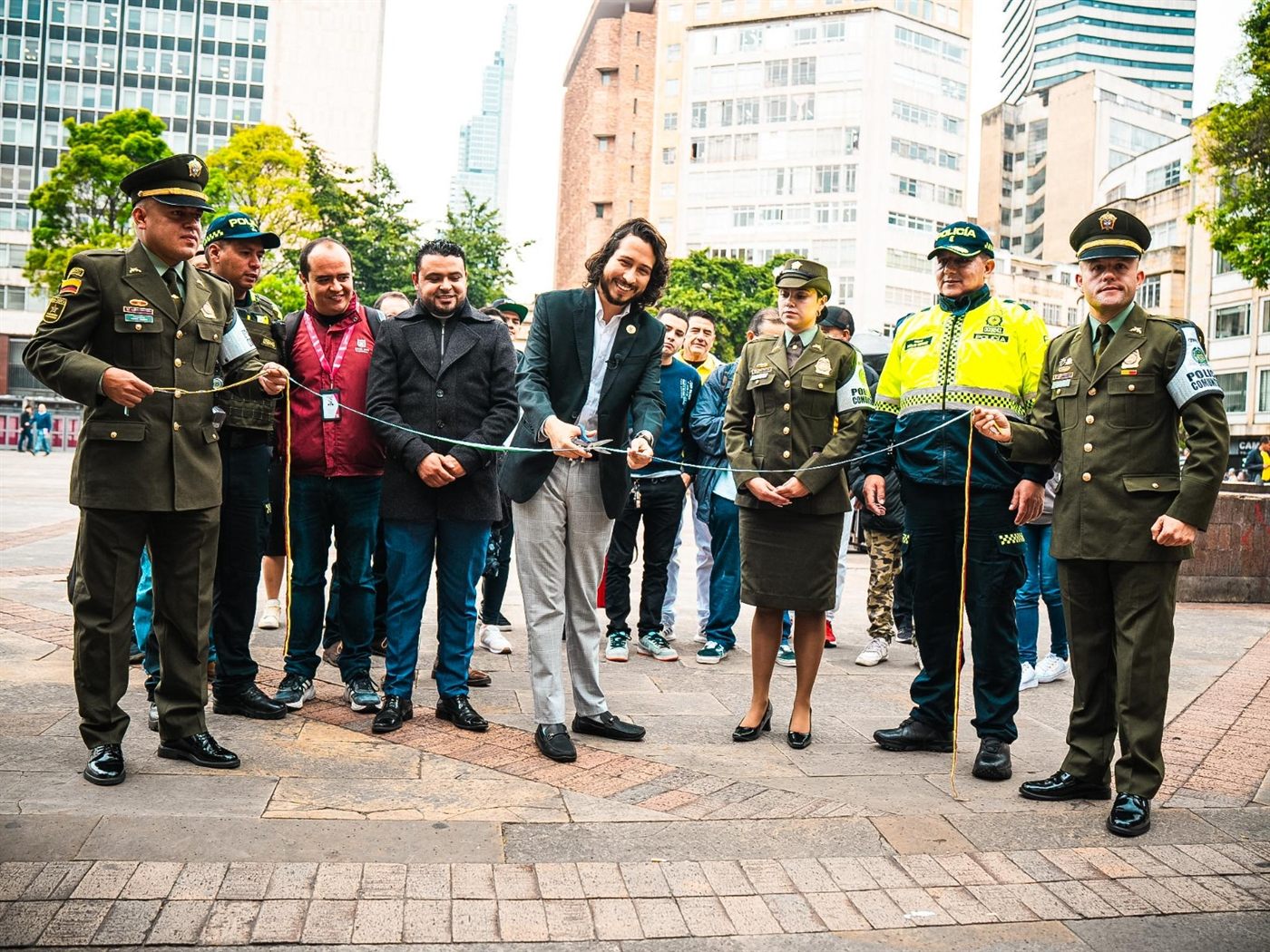 Julián Sastoque corta la cinta en un acto público en el centro de Bogotá, acompañado por la Policía Metropolitana